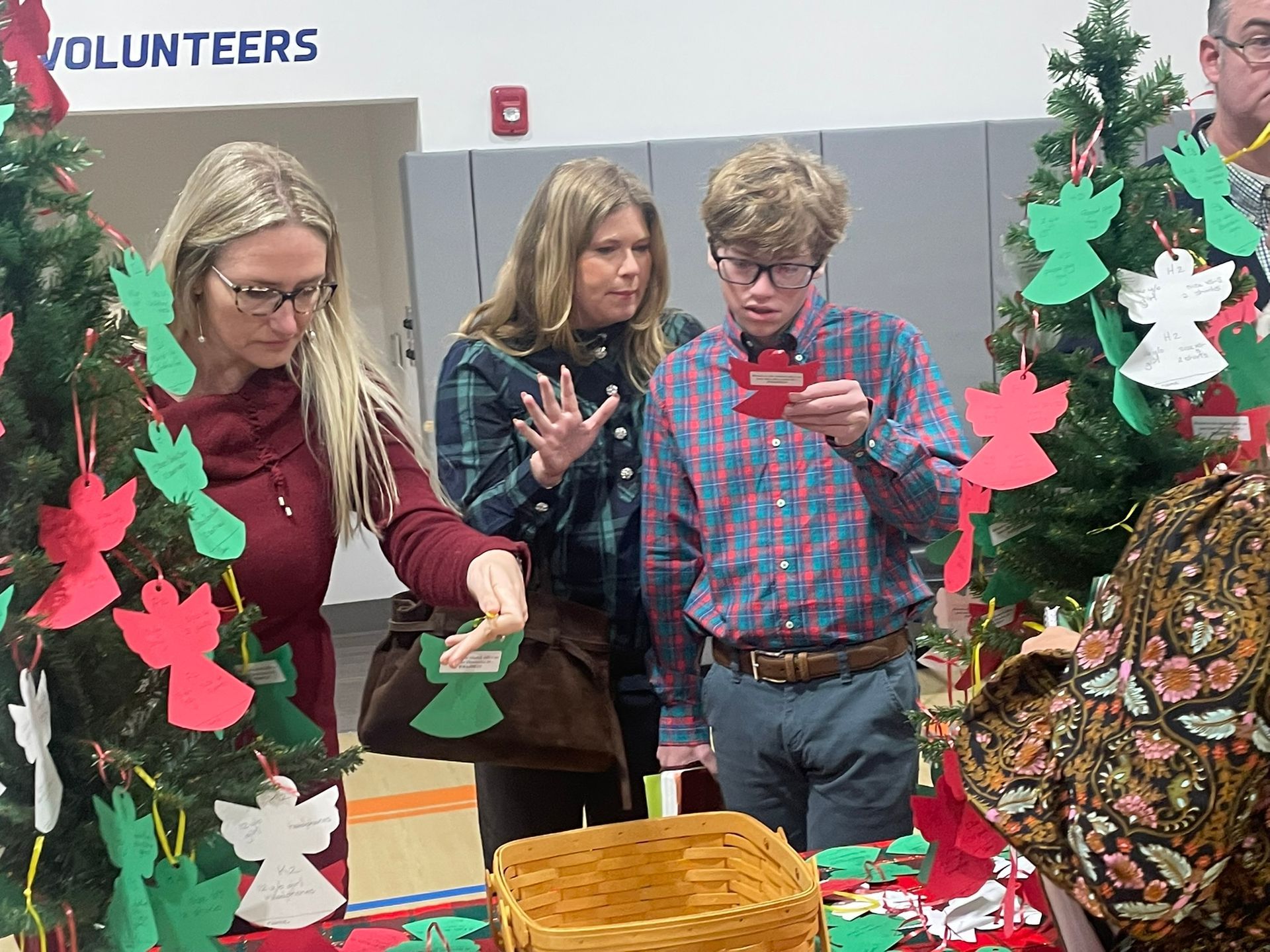 A woman is holding a box of snacks in front of a sign that says snacks.