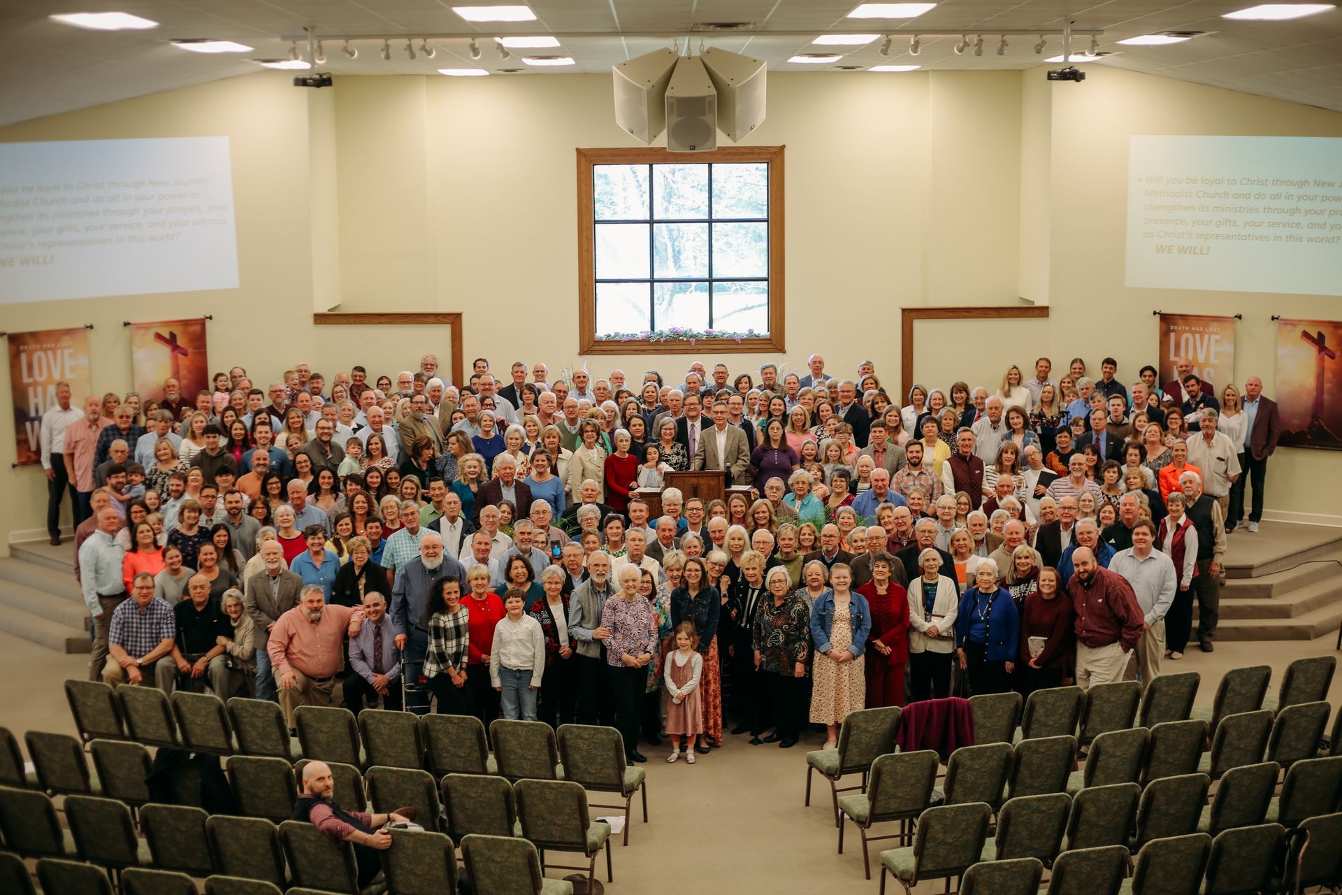 Large group of people gathered in a church auditorium, posing for a photo.