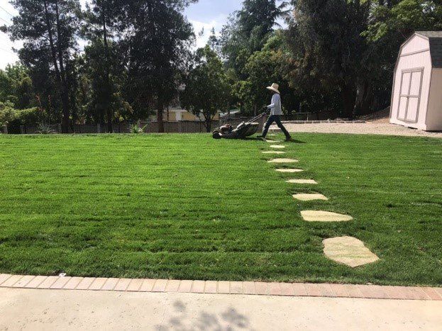 Man Mowing Front Yard Garden | H & R Gardening and Landscaping