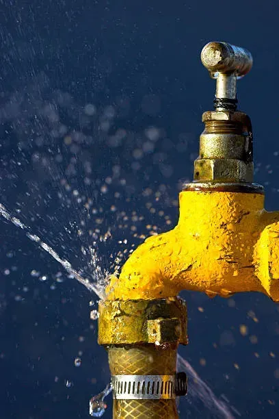 A person is pouring water from a faucet into a glass in Vancouver, WA