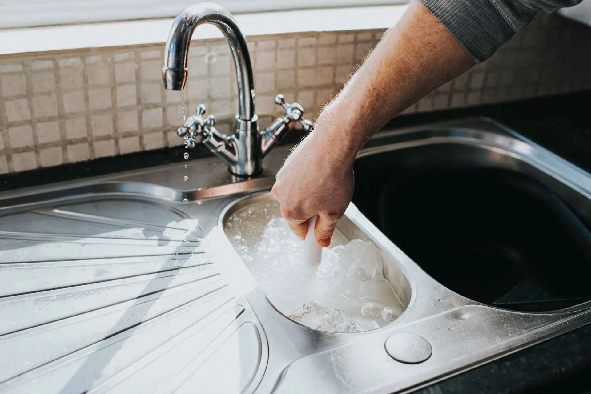 A person is fixing a bathroom sink with a wrench in Vancouver, WA