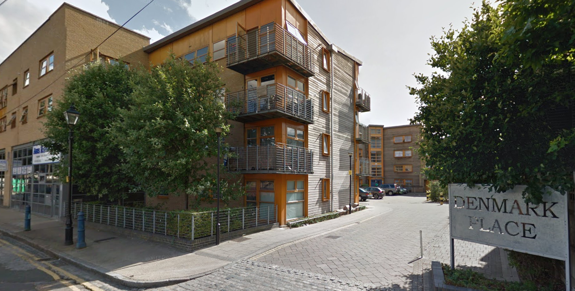 Apartment building with wooden balconies on Denmark Place, London. Sign visible.