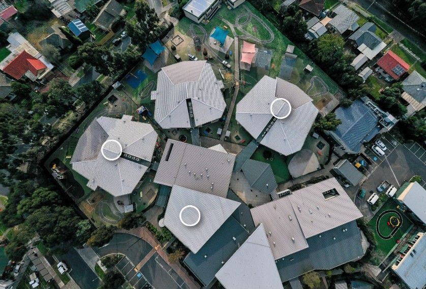 Aerial view of buildings with unique hexagon roofs and a residential area.