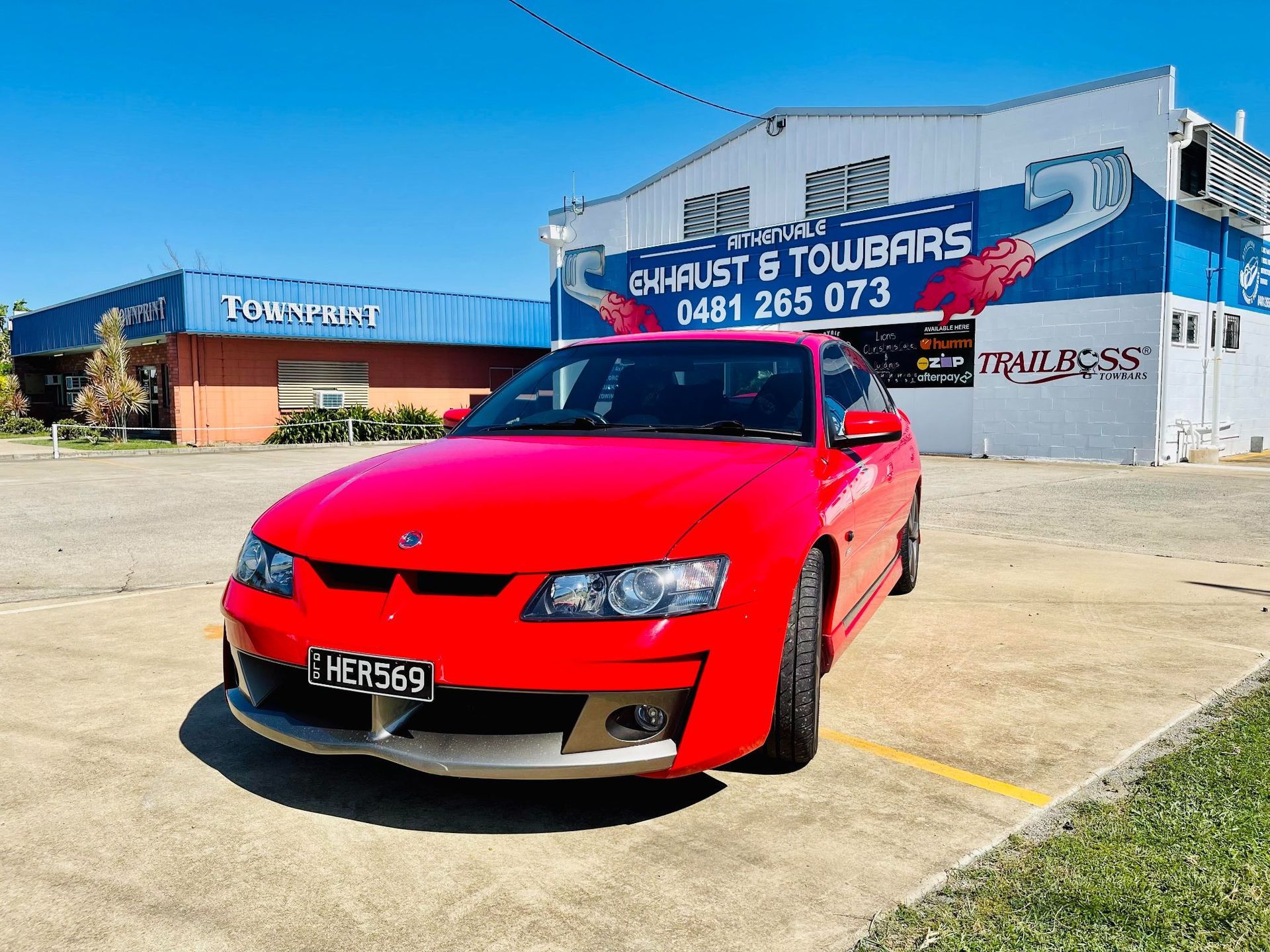 Red Car Parked in Front of an Exhaust and Towbar Shop — Aitkenvale Exhausts & Towbars Pty Ltd In Aitkenvale, QLD