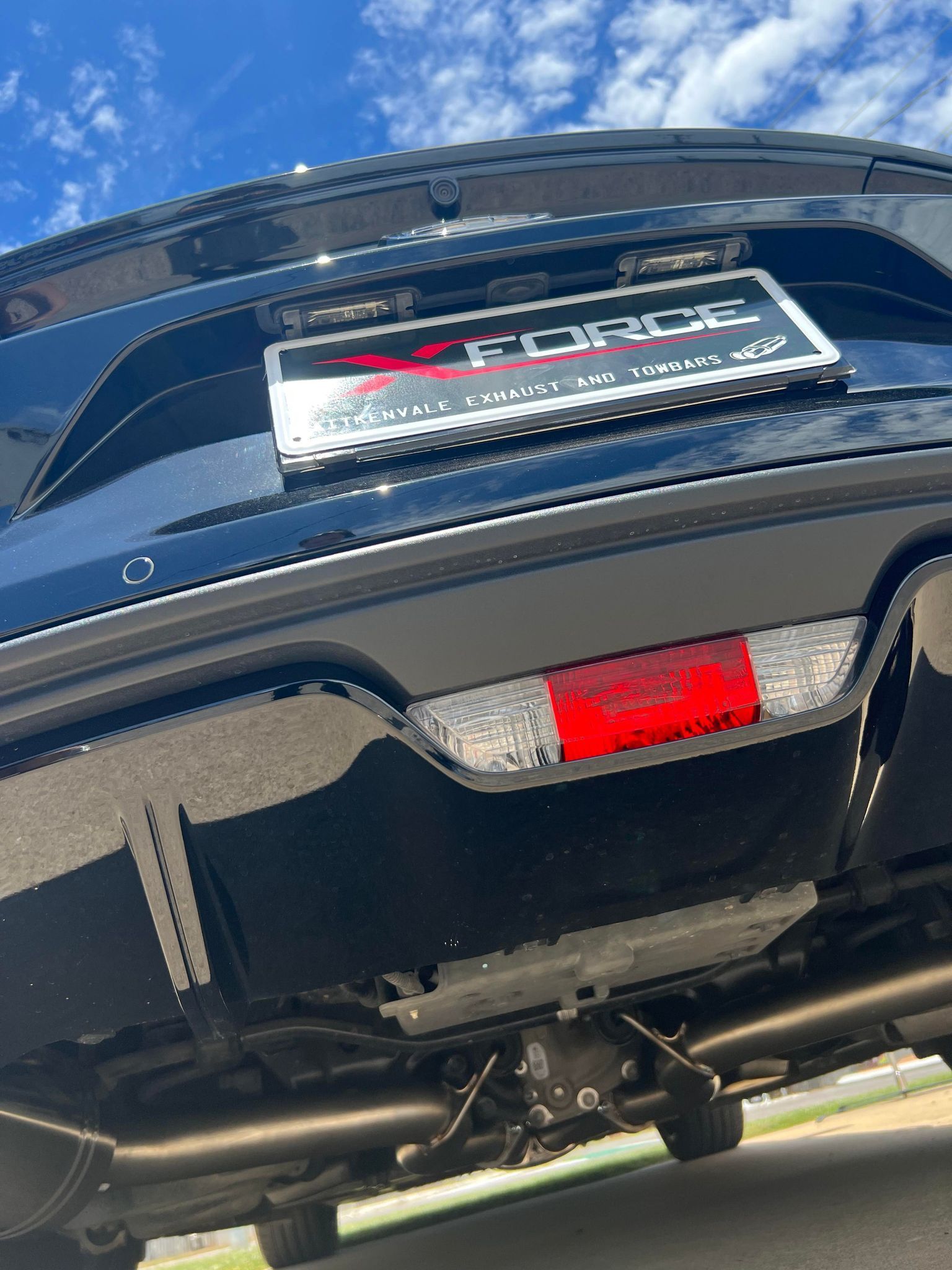 Black Car Rear, Angled Up, Showing Exhaust Pipes — Aitkenvale Exhausts & Towbars Pty Ltd In Aitkenvale, QLD