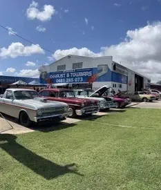 Cars Parked on a Grassy Area in Front of a Building — Aitkenvale Exhausts & Towbars Pty Ltd In Aitkenvale, QLD