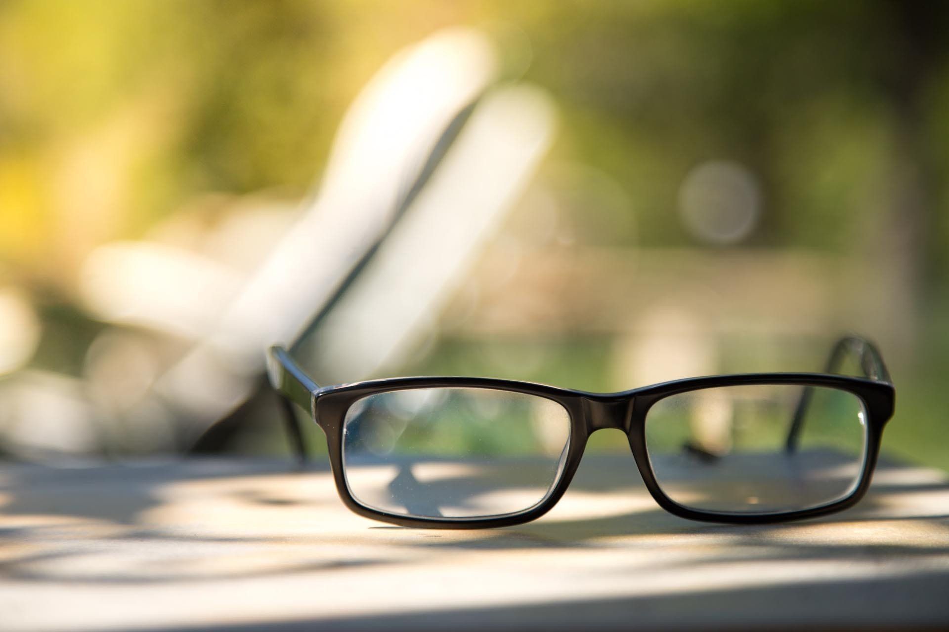 Eine Brille steht auf einem Holztisch.