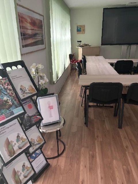 Ein Raum mit Tischen und Stühlen und einer Auslage mit Zeitschriften