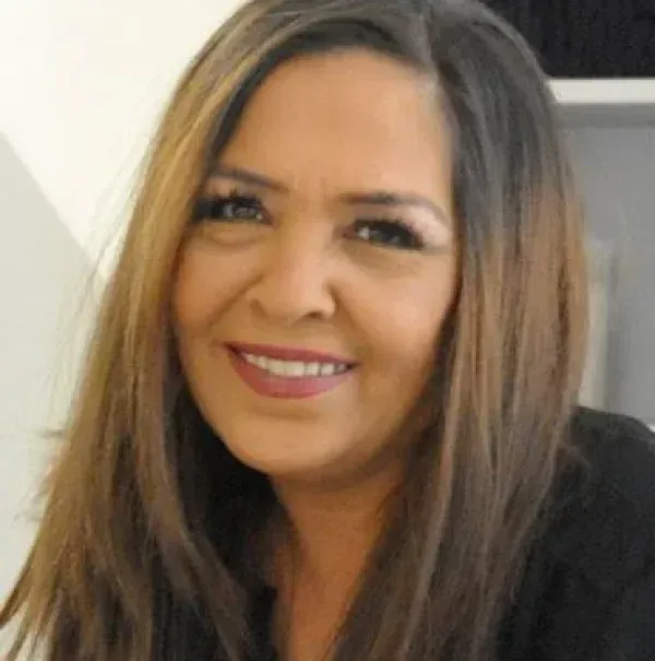 Eine Frau mit langen braunen Haaren lächelt in die Kamera.