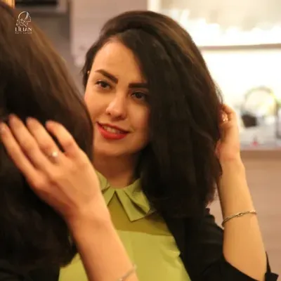 Eine Frau in einem grünen Kleid berührt ihr Haar