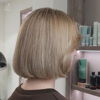 Eine Frau mit kurzen blonden Haaren steht in einem Salon.