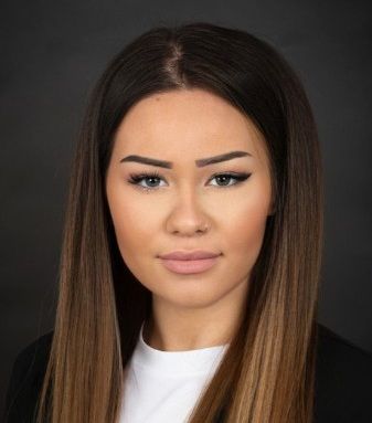 Eine Frau mit langen braunen Haaren lächelt in die Kamera.