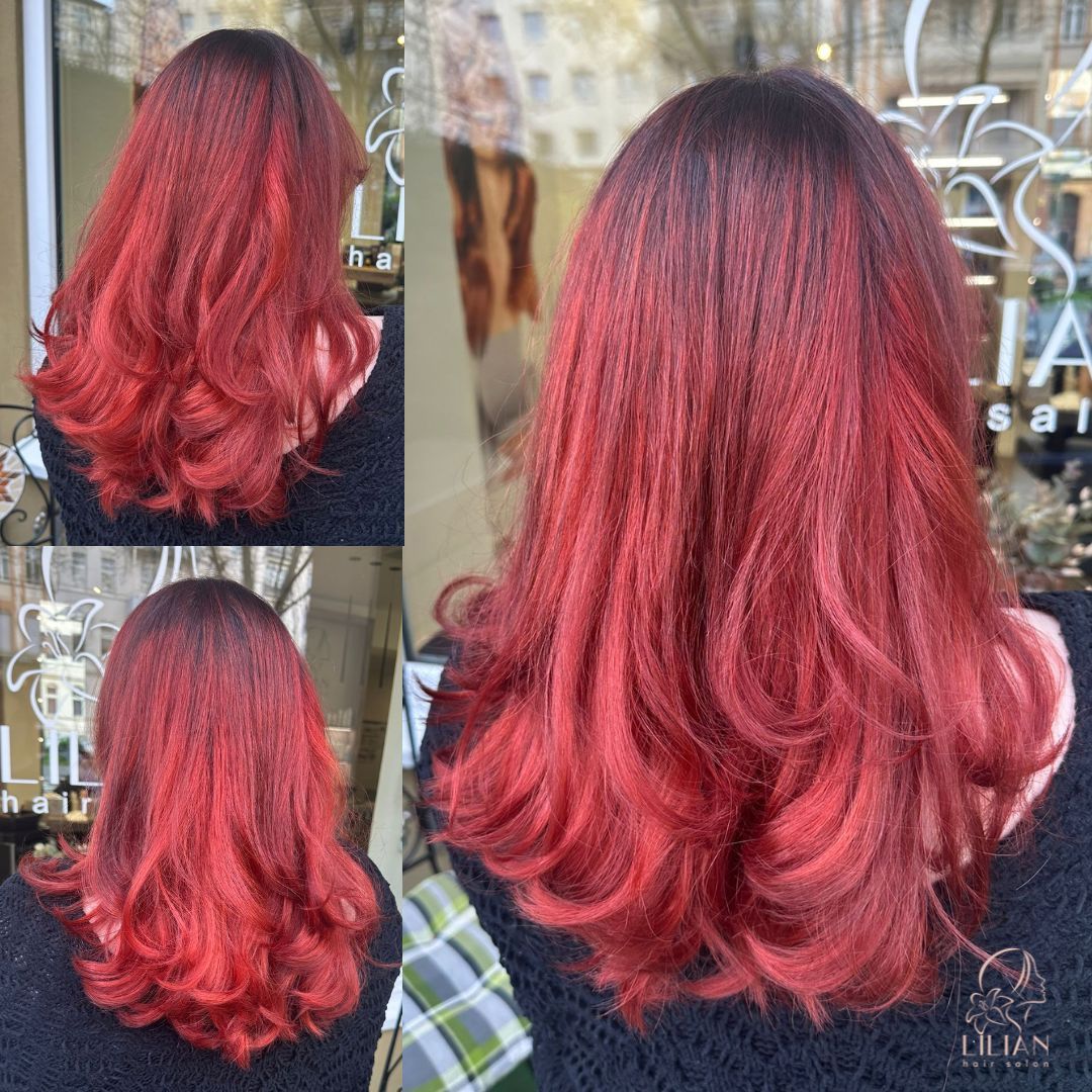 Eine Frau mit langen roten Haaren steht vor einem Fenster.