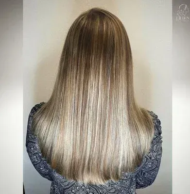 Der Hinterkopf einer Frau mit langen blonden Haaren.