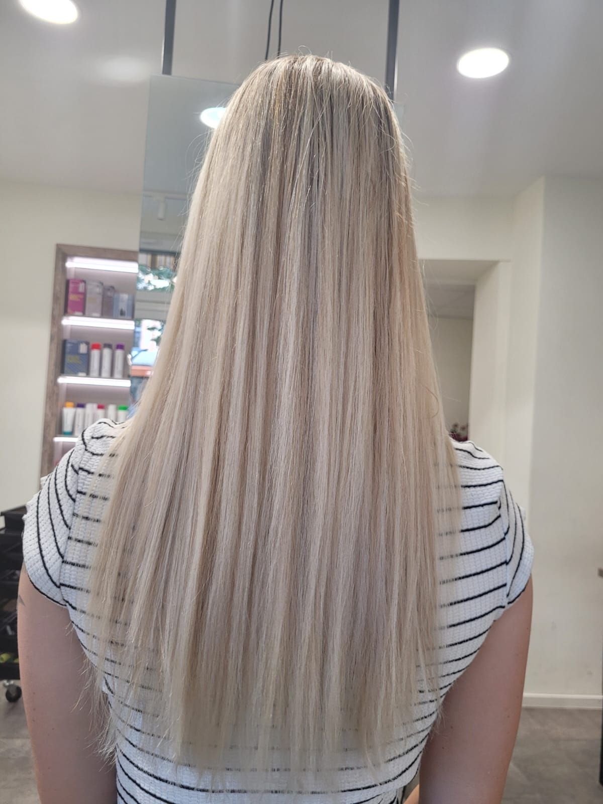 Eine Frau mit langen blonden Haaren sitzt in einem Salon.