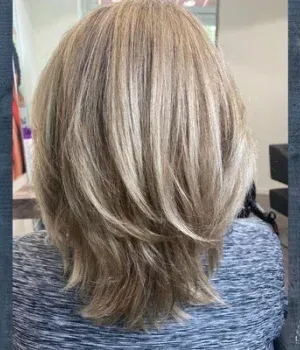 Zu sehen sind die blonden Haare einer Frau auf der Rückseite.