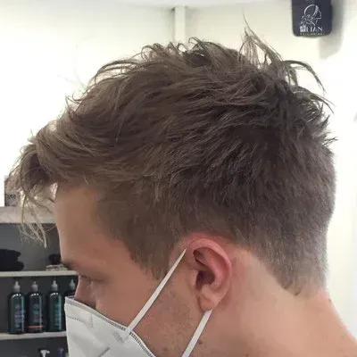 Ein Mann trägt in einem Salon eine Gesichtsmaske.
