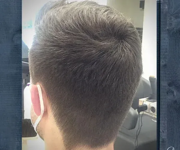 Der Hinterkopf eines Mannes mit kurzen Haaren und Bart.