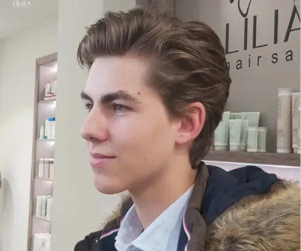 Ein junger mann steht vor einem lilia friseursalon