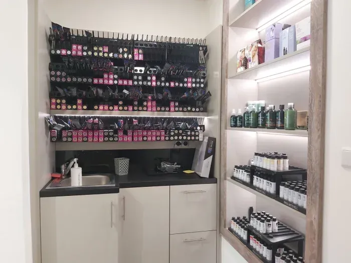 Eine Küche mit Spüle und Regalen voller Kosmetikflaschen.