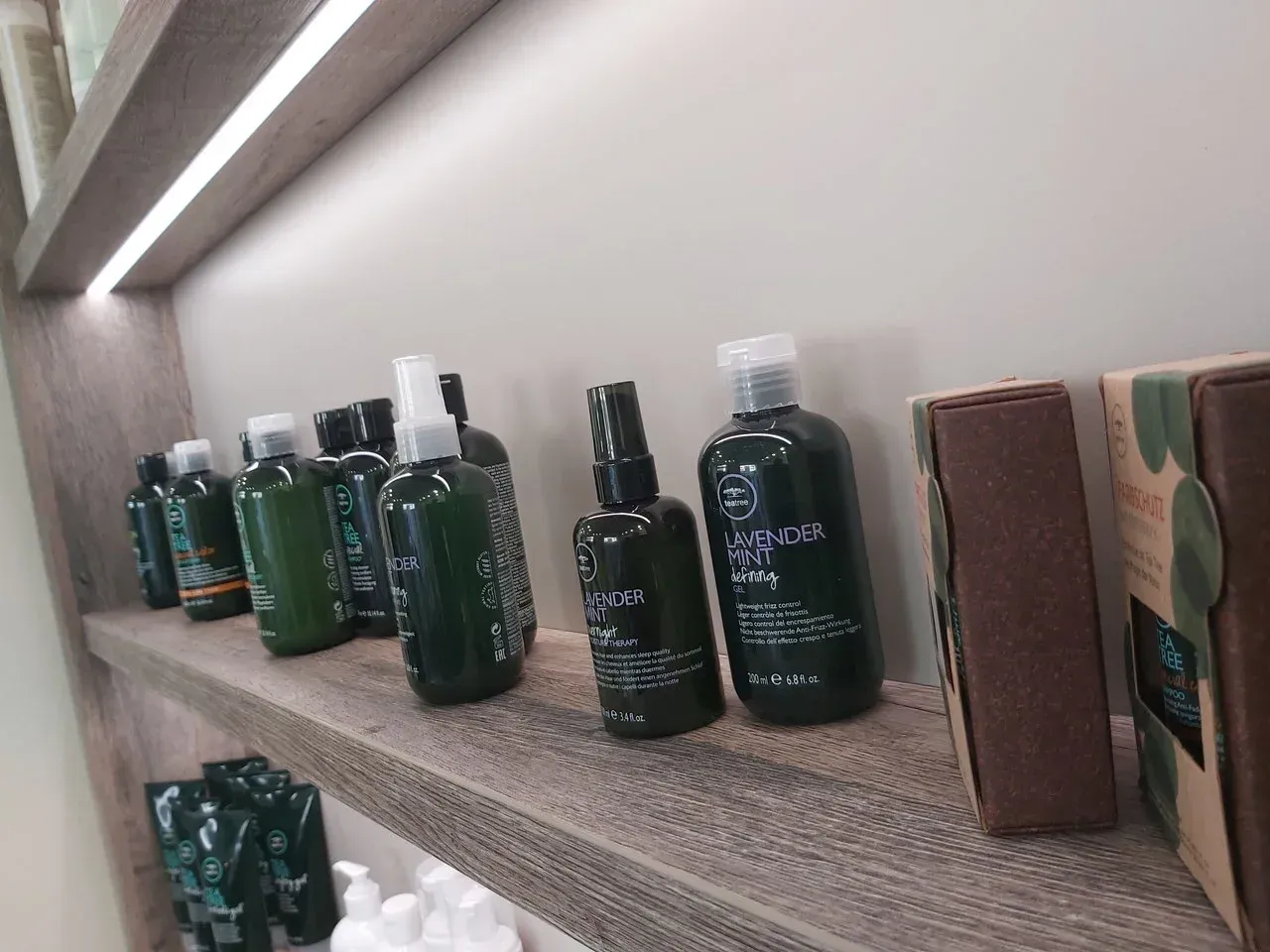 Eine Reihe grüner Flaschen steht aufgereiht auf einem Holzregal.