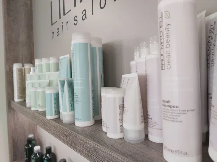 Ein Regal voller Flaschen mit Haarpflegeprodukten in einem Friseursalon.