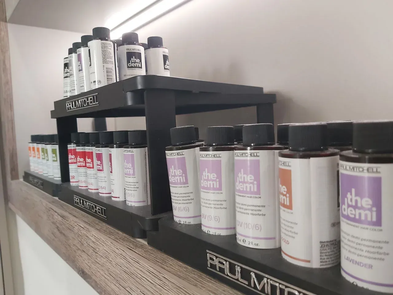 Ein Regal voller Flaschen mit Haarpflegeprodukten in einem Salon.