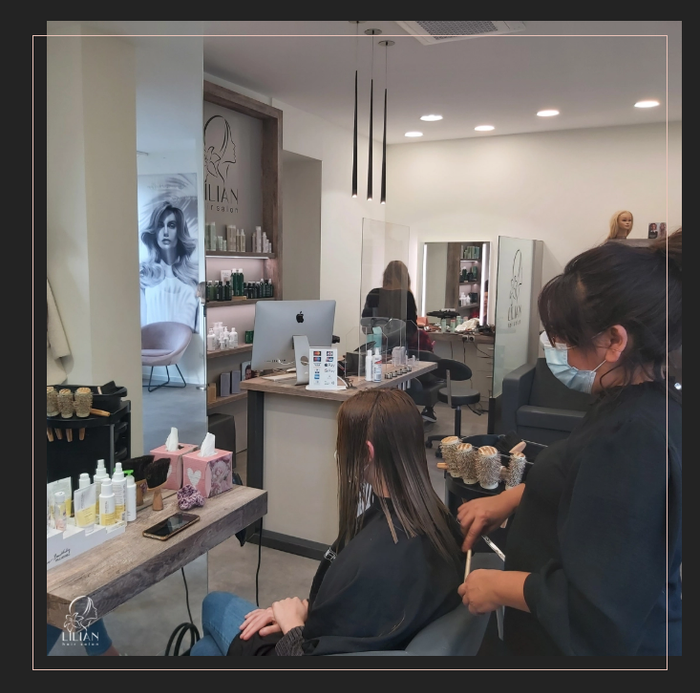 Eine Frau mit Maske lässt sich in einem Salon die Haare machen