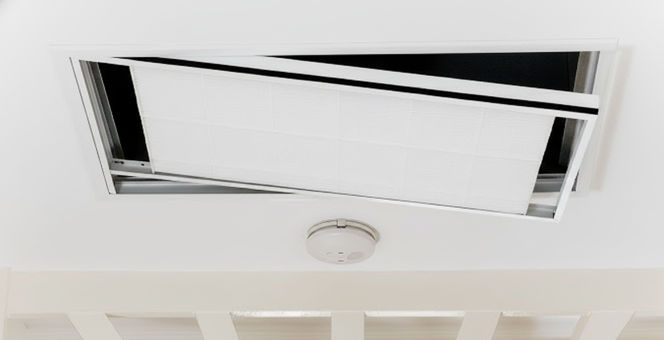White ceiling vent open, revealing a dark interior, near a smoke detector.