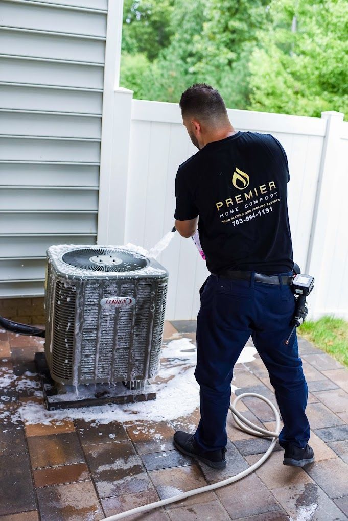 a man is cleaning an air conditioner with a hose .