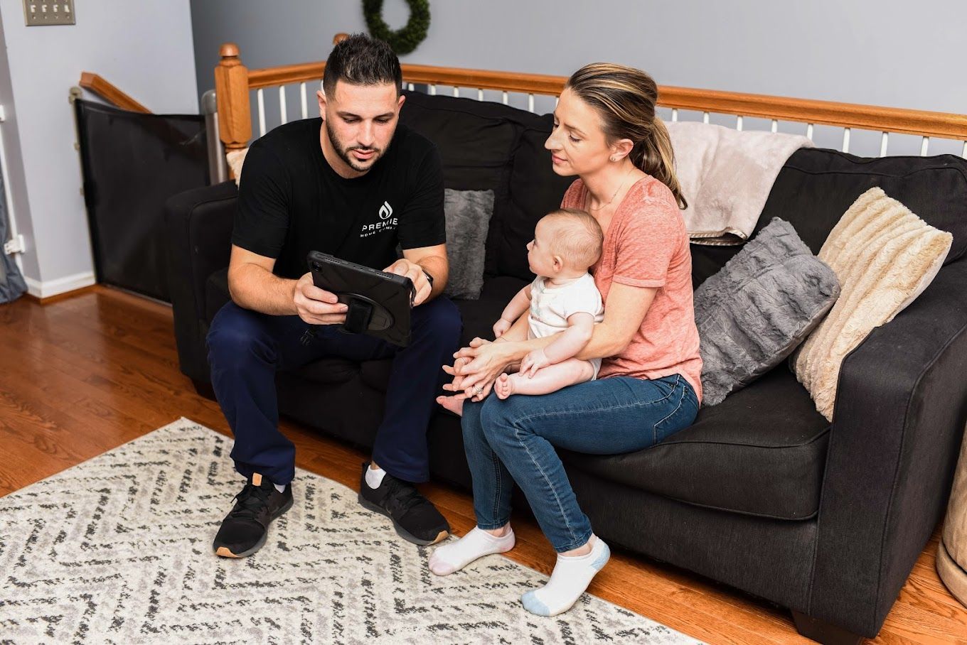a man and a woman are sitting on a couch with a baby .
