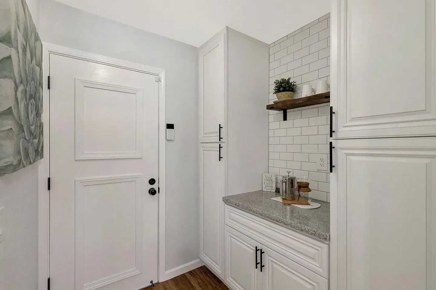 White pantry with countertops, cabinets, shelf, and a Dutch door.