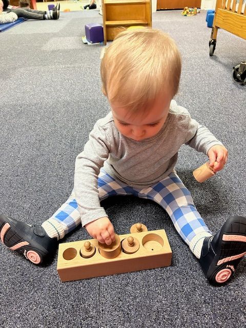 Infant playing with wooden toy