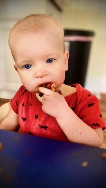 Infant playing with wooden toy