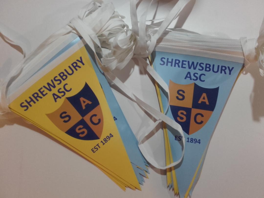 Two shrewsbury asc flags sit on a table