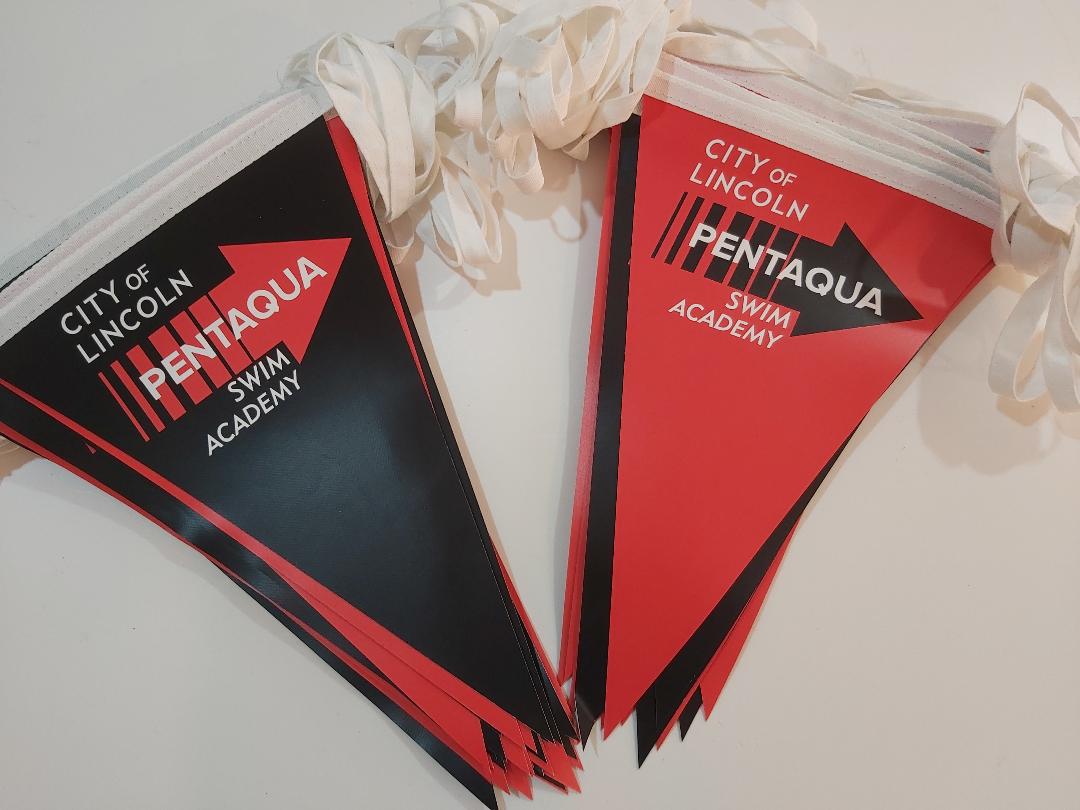 Two red and black flags that say city of lincoln pentaqua