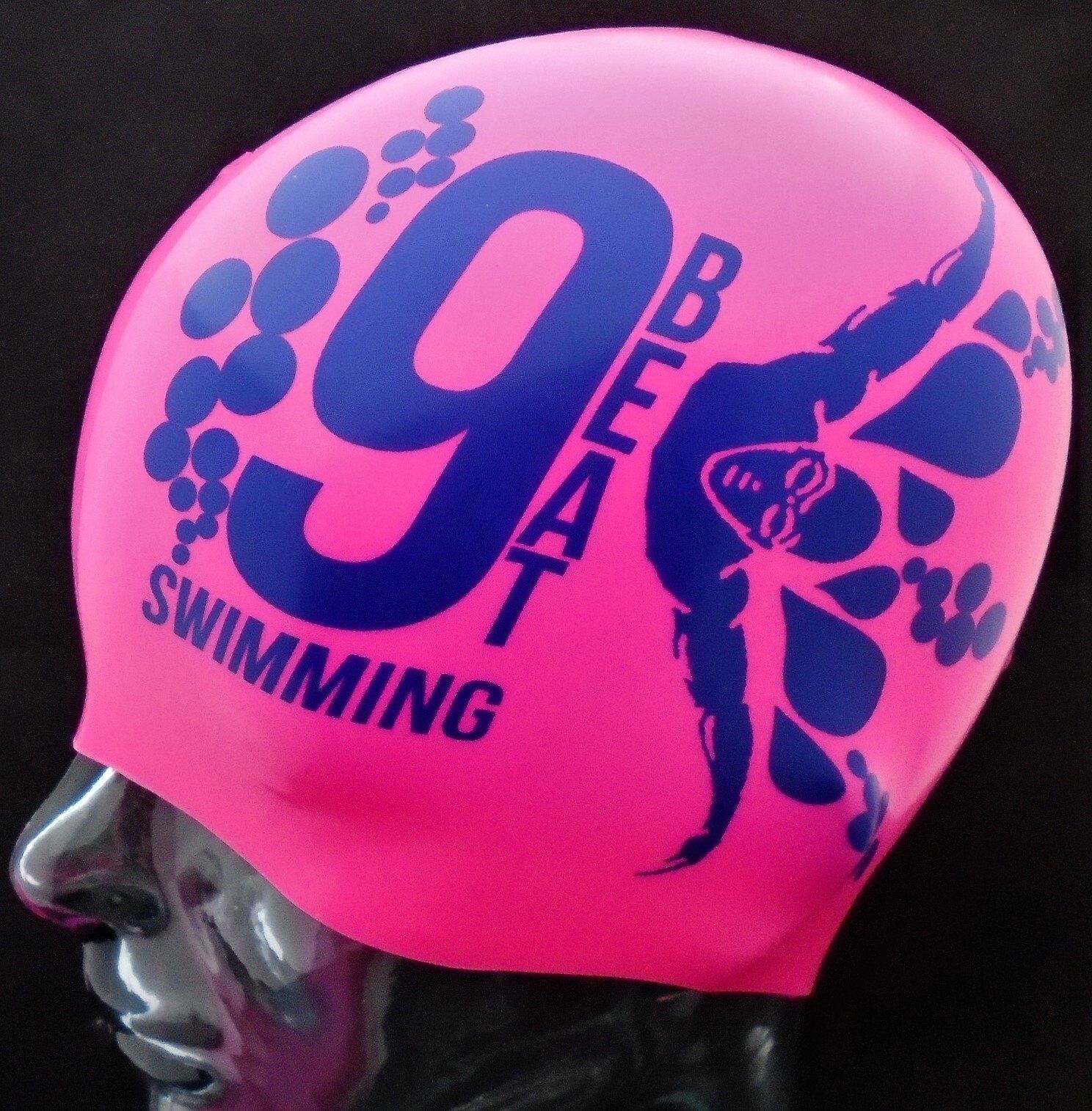 A pink swim cap with the number 9 on it