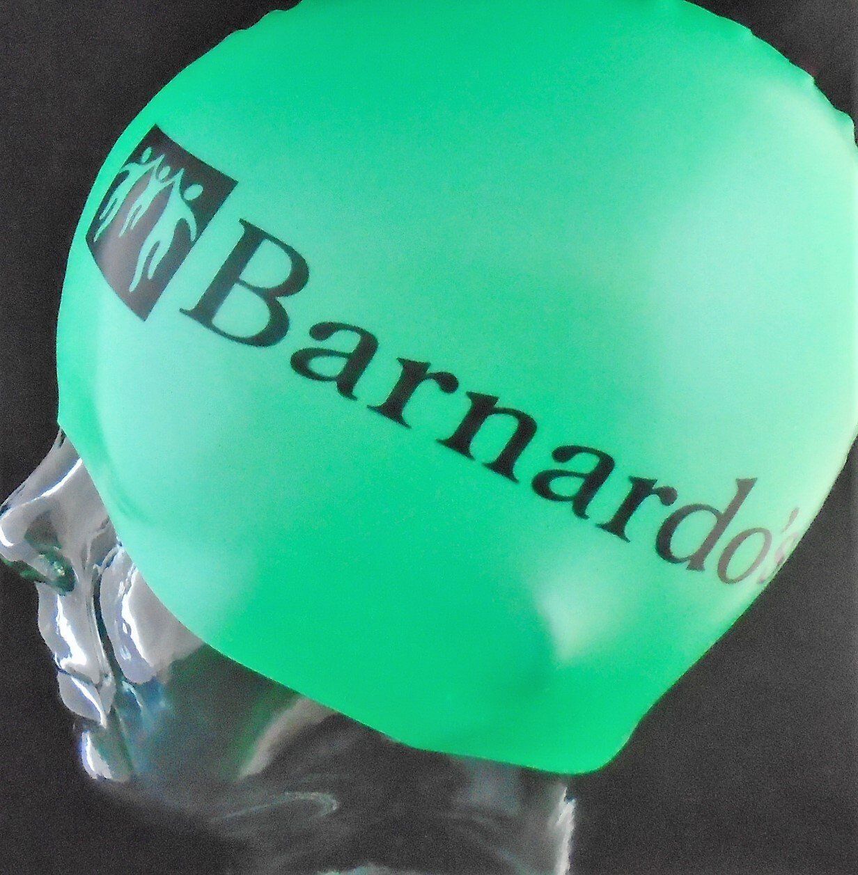 En grøn badehætte med teksten Barnardo på