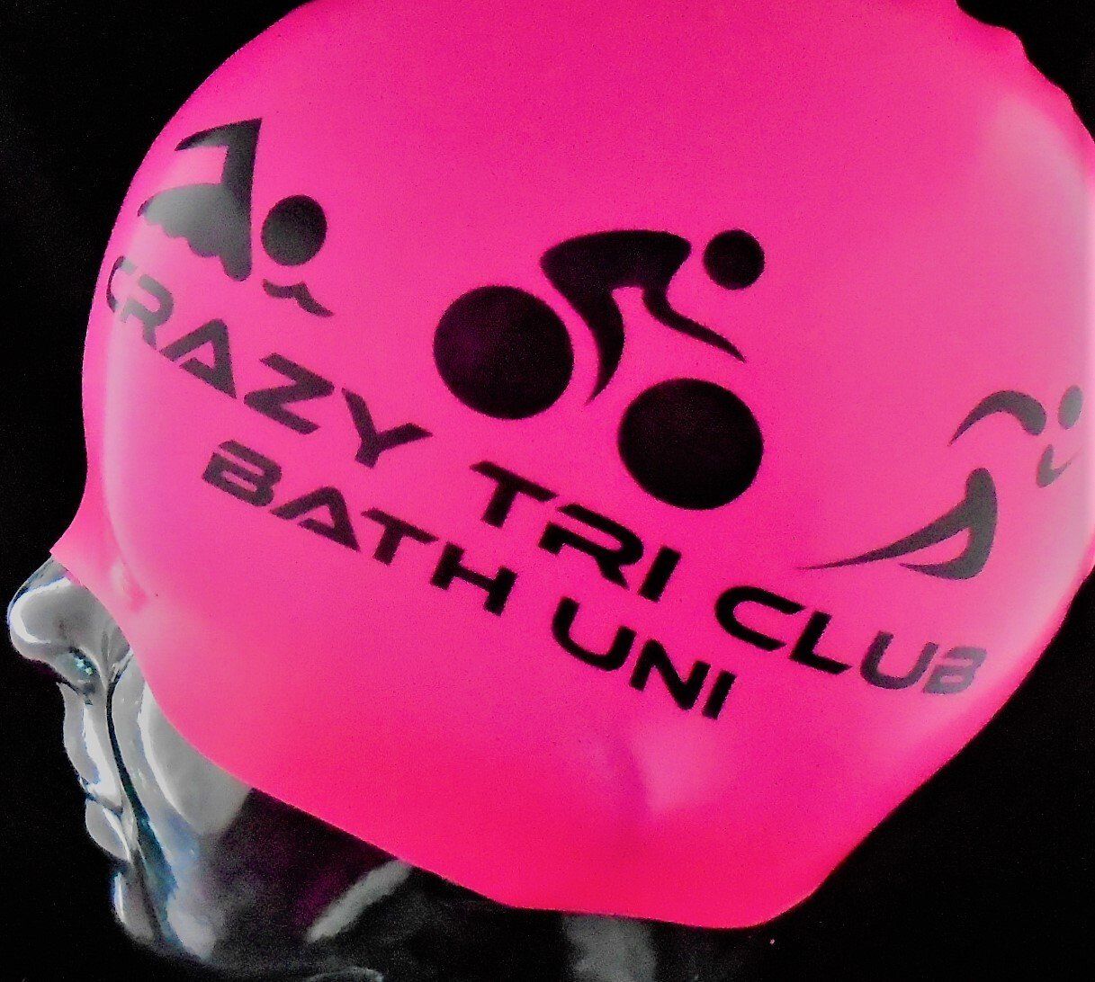 A pink swim cap that says crazy tri club bath uni