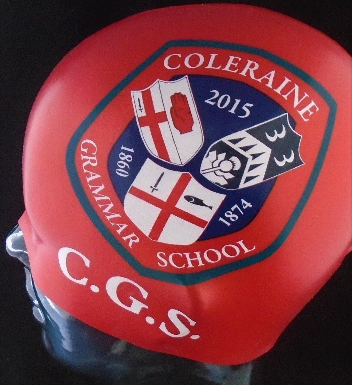 En rød CGS badehætte med et våbenskjold på