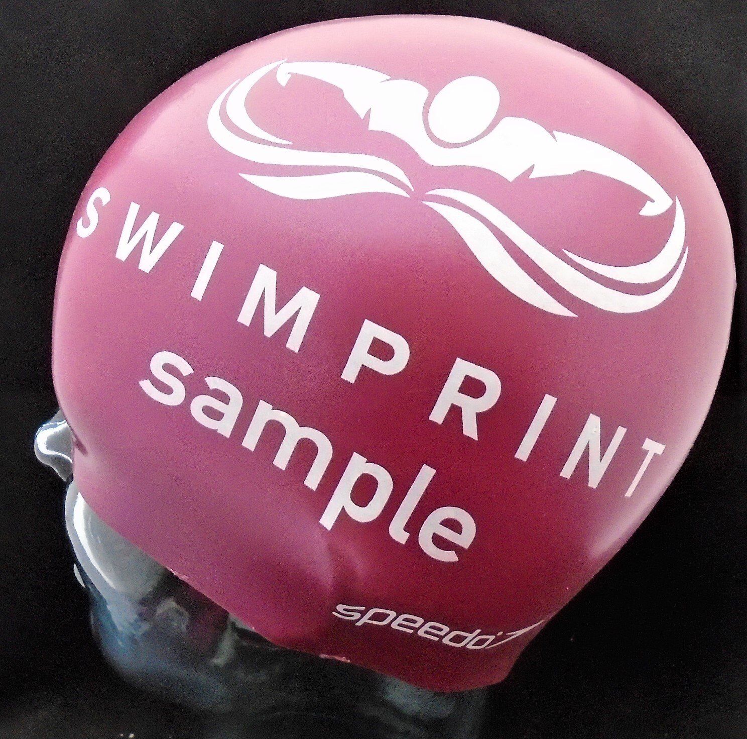 A pink swim cap that says swimprint sample on it