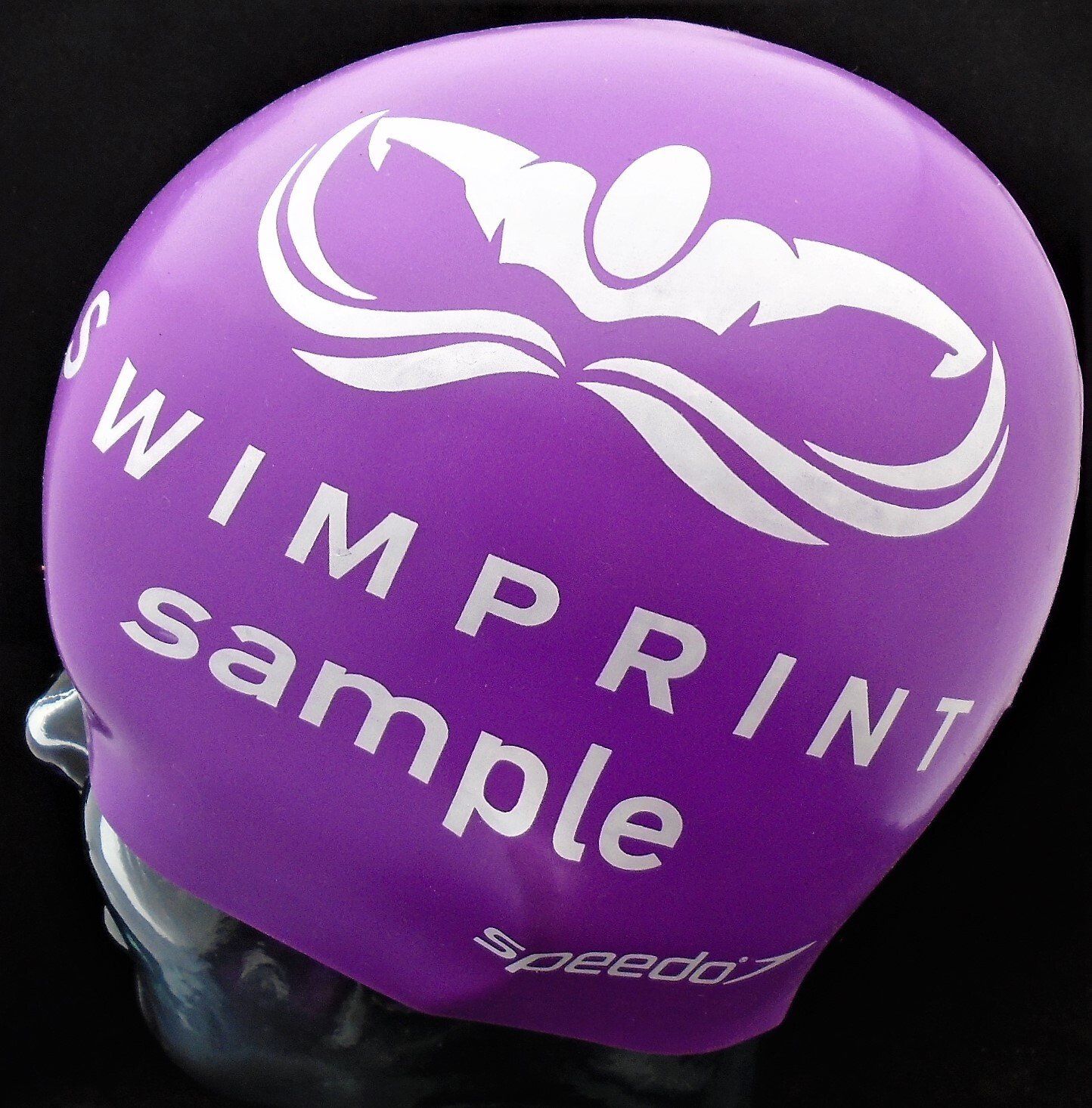 A purple swim cap that says ' swimprint sample ' on it