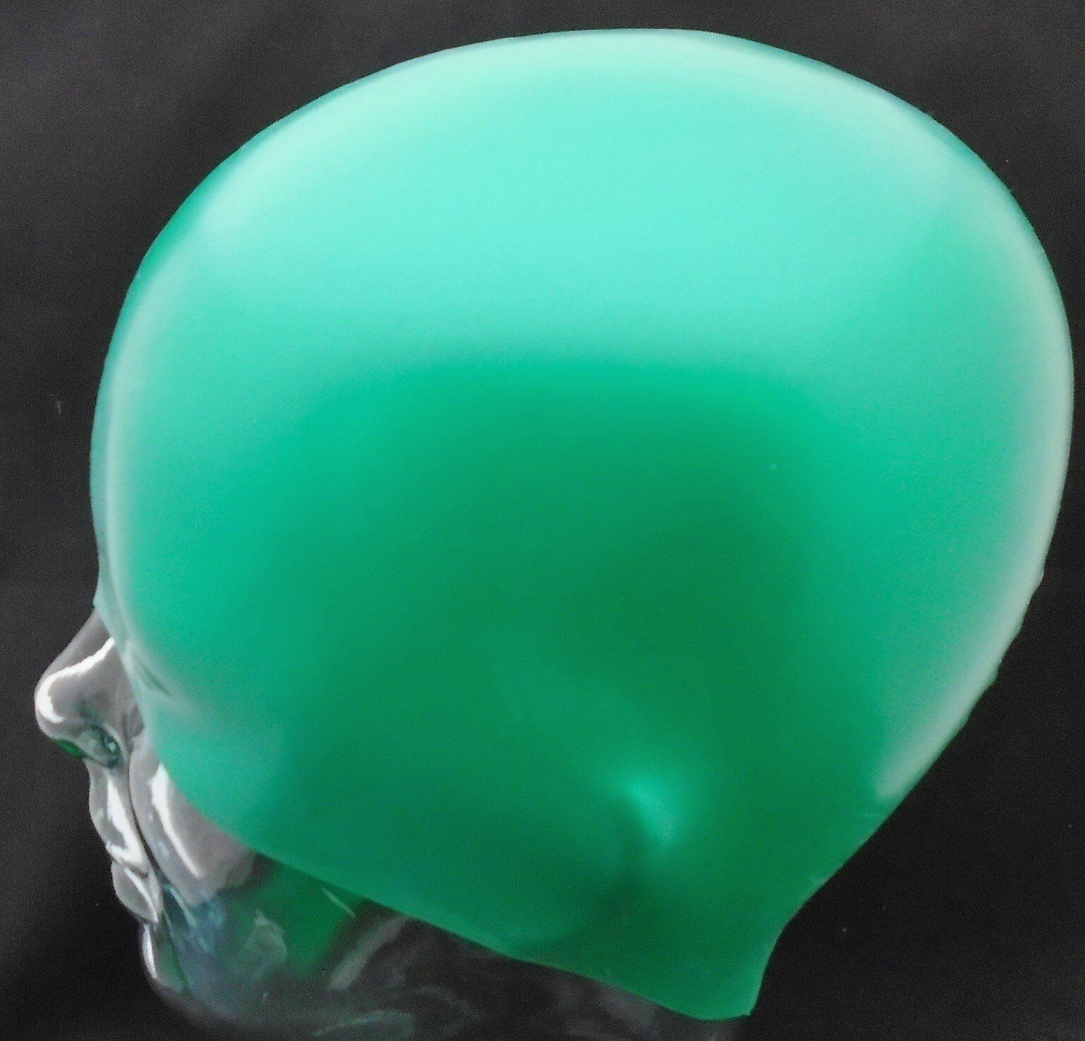 A green swimming cap is on a mannequin head
