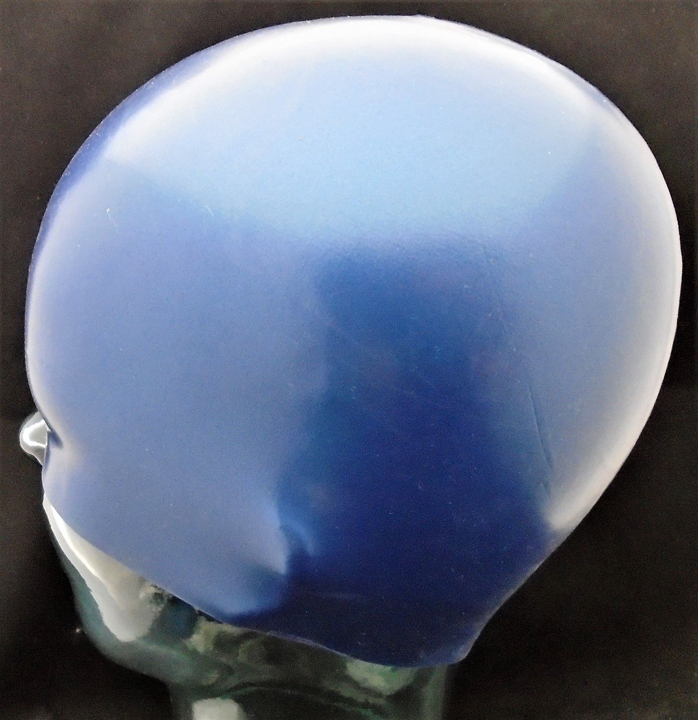 A blue swimming cap is on a mannequin head