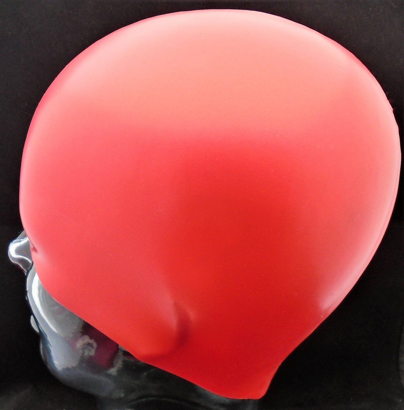 A red swim cap is on a mannequin head