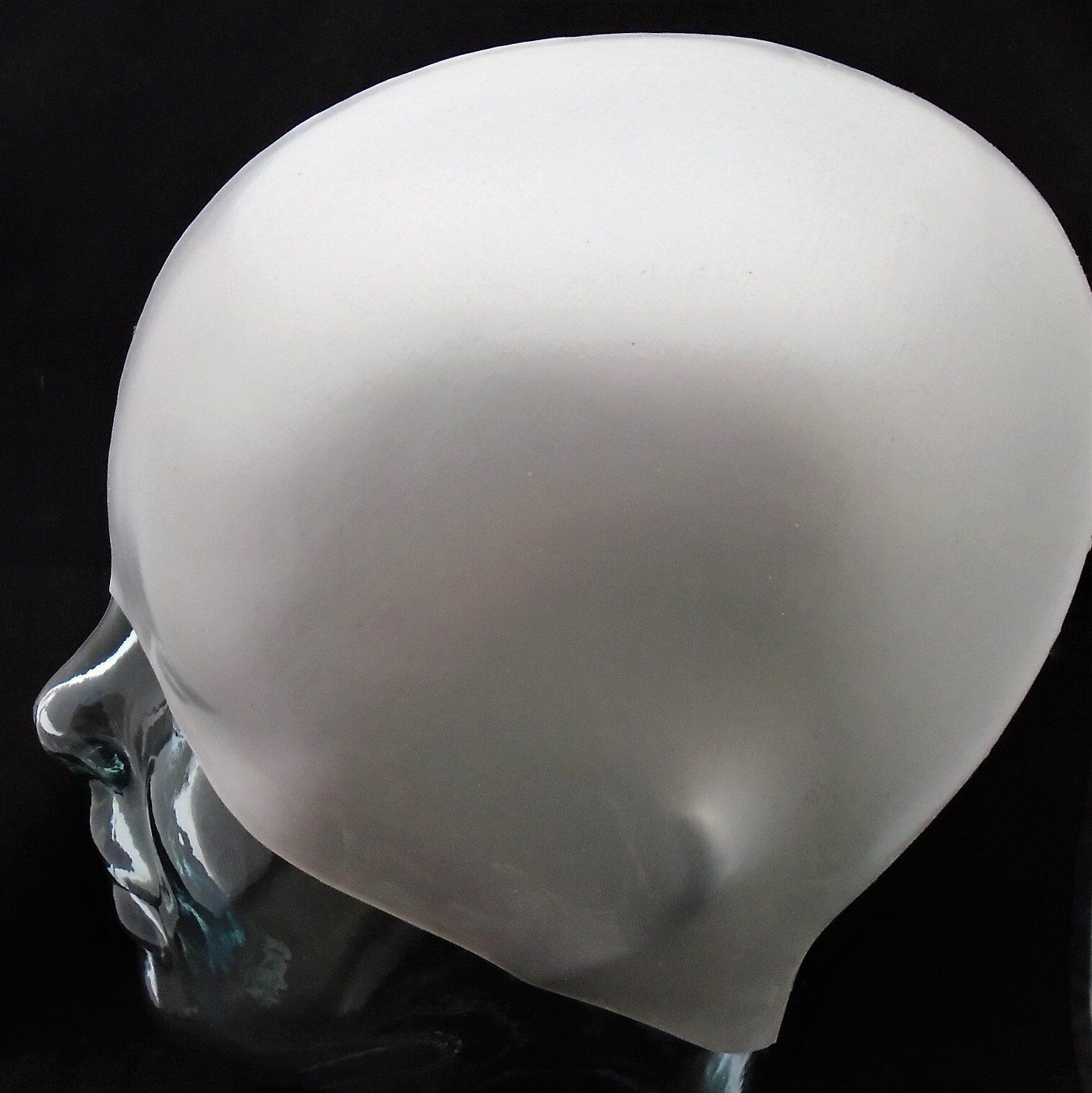 A mannequin head with a silver hat on it
