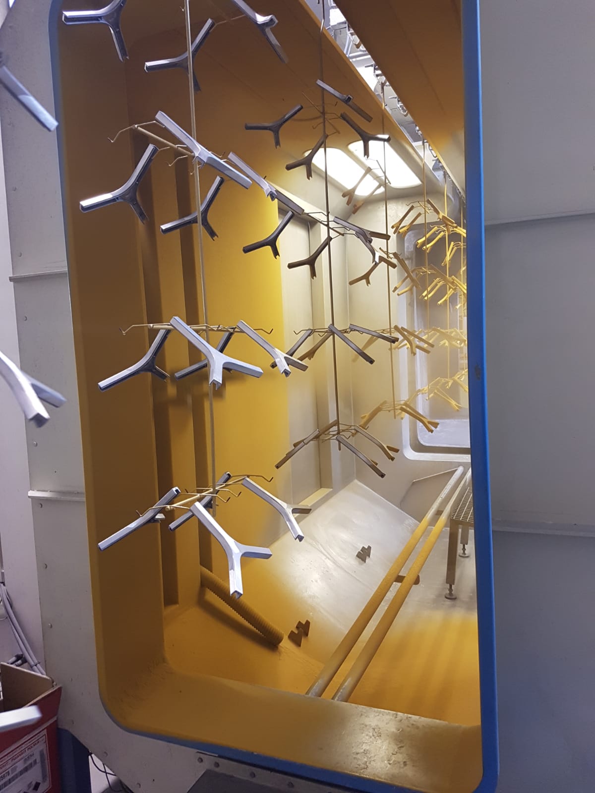 Mobiletto asciugabiancheria industriale giallo con ganci in metallo e vassoio vuoto all'interno