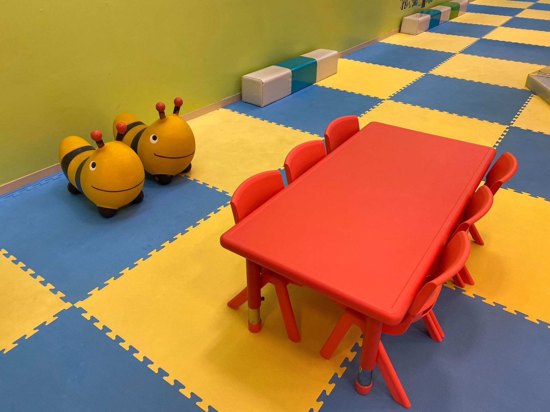 A red table and chairs are in a room with a checkered floor.