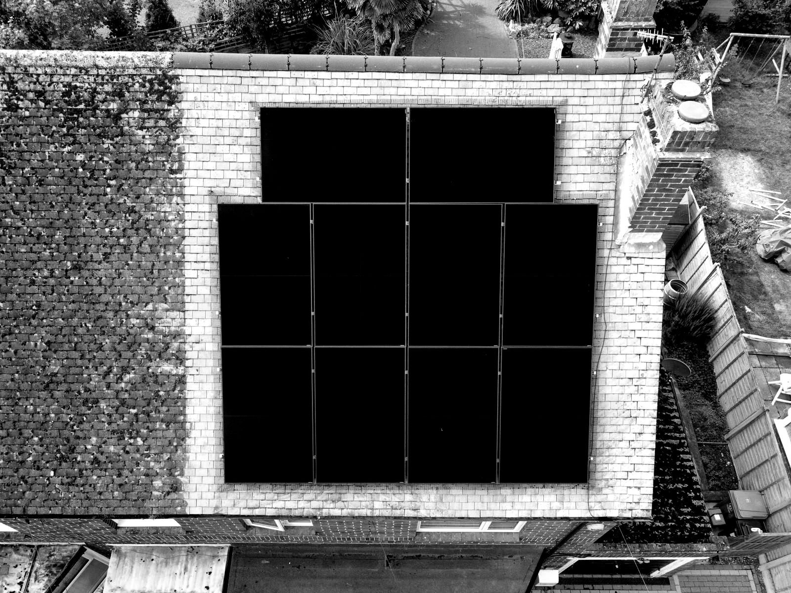 An aerial view of a brick building with solar panels on the roof.