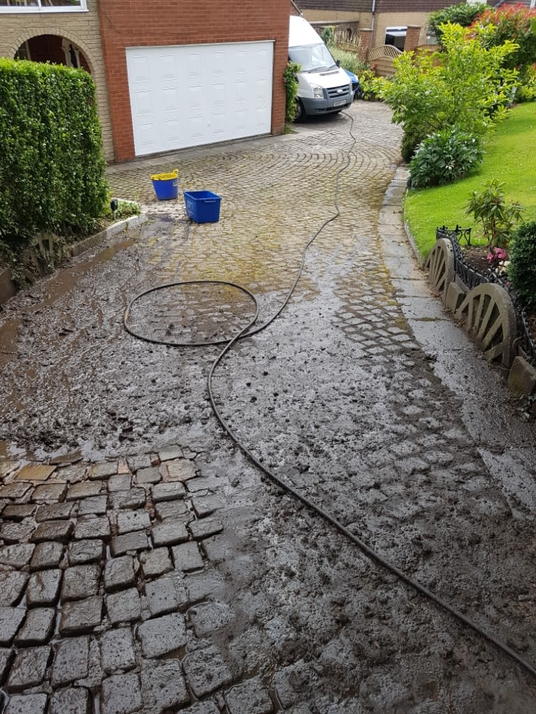 dirty sloped brick driveway